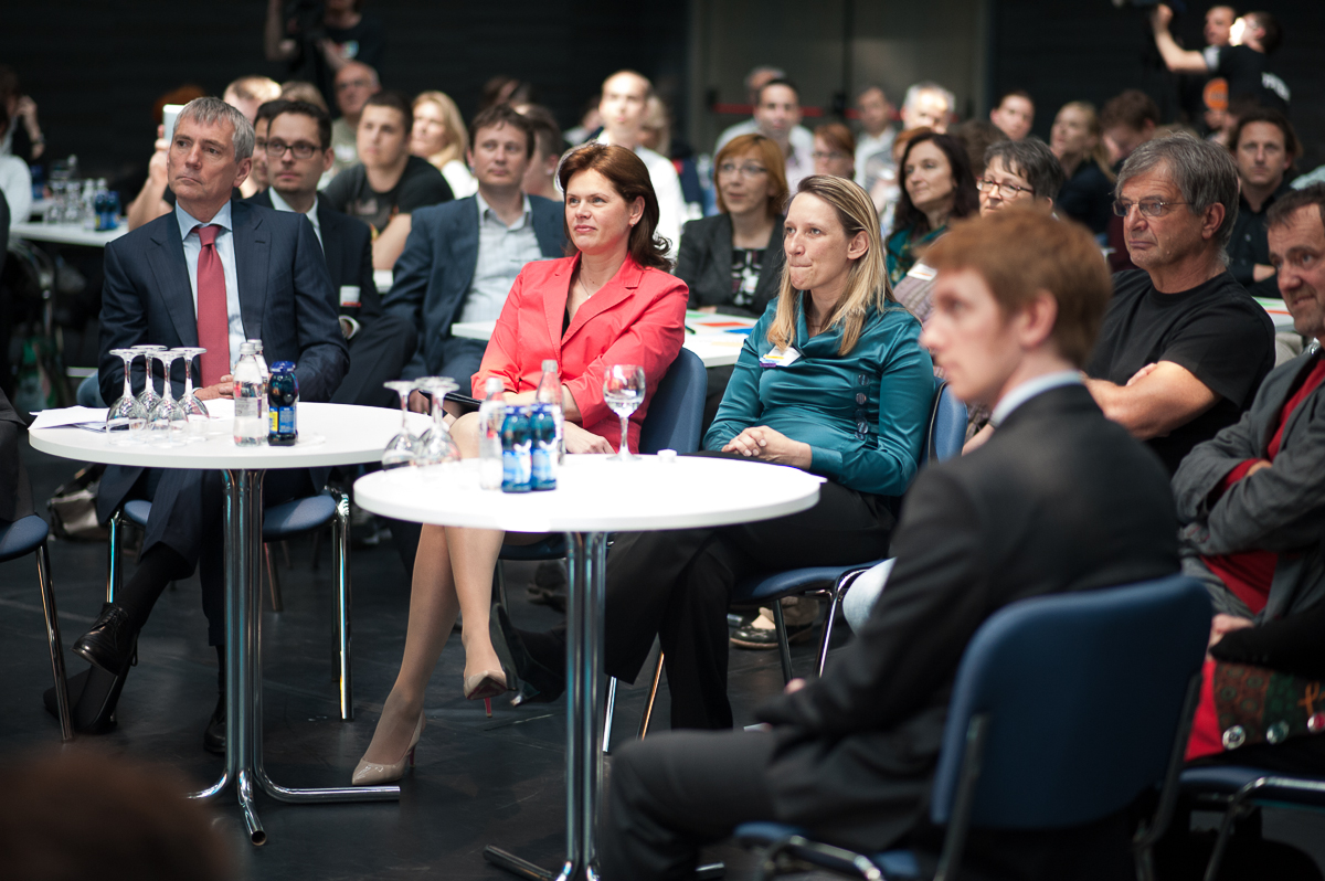 Slovenian Prime Minister Alenka Bratuscek and Sandi Cesko (left), watching student entrepreneurs' pitches
